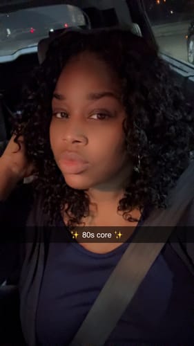 Reviewer in a car at night showing her dark, curly Spanish Curl Human Crochet Hair in a shoulder-length style.