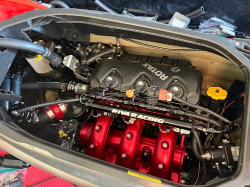 Customer's black Motion Raceworks oil catch can installed in the engine bay of a jetski with a red manifold.