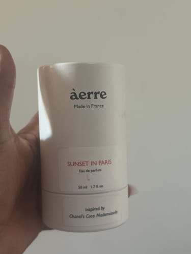 Reviewer holding the white cylindrical packaging for the Black Blaze fragrance.