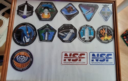 Reviewer's NSF stickers from the sticker sheet displayed in a frame below a large collection of patches.