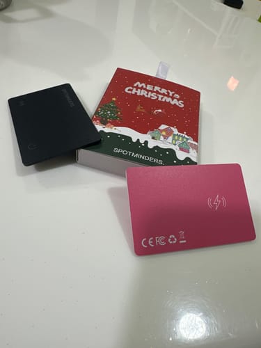 Customer's two SPOTMINDERS Wireless Chargers, one black and one pink, with their Christmas-themed packaging.