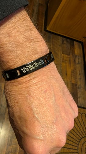 Customer wearing the We The People Magnetic Black Bracelet, with the script engraving visible on their wrist.