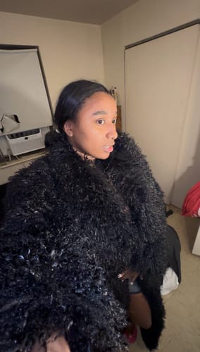 Reviewer wearing the textured black Faux Fur Plush Long Coat indoors.