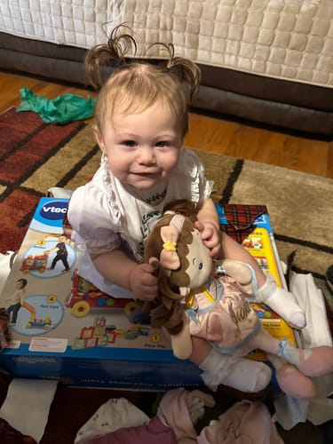 A customer's photo of a smiling child holding the brown-haired Personalized Princess Twinkle doll.