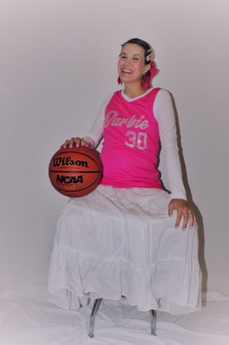 Customer wearing the pink sequined basketball jersey over a white shirt while holding a basketball.