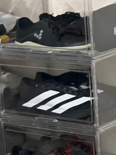 A customer's black adidas Adizero EVO SL Running Shoes with white stripes displayed inside a clear storage box.