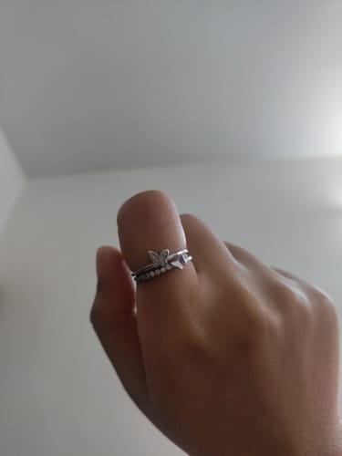 Close-up of the Silver Layered Butterfly Ring on a customer's thumb, showing the two bands and butterfly design.