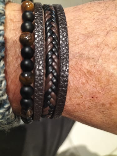 Client portant le bracelet Orisha multi-rangs, montrant les perles et les lanières de cuir tressé au poignet.