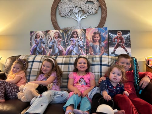 Customer's four Rainbow Princess canvases and one other portrait displayed on a couch behind five children.