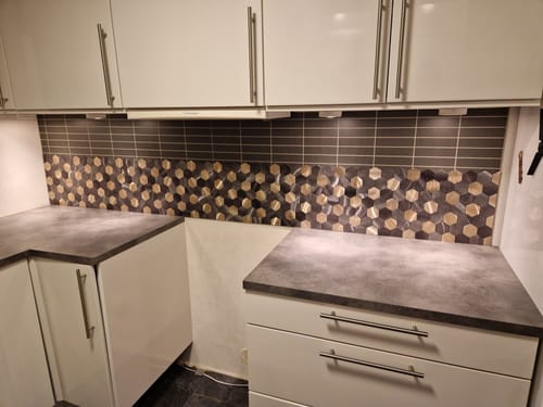 Anmelders kjøkken med nymonterte Latte hexagon selvklebende veggfliser som backsplash.