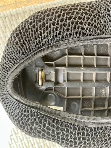 Customer's close-up of the black Wind Rider Seat Cover pulled taut over the underside of a seat, covering the latch mechanism.