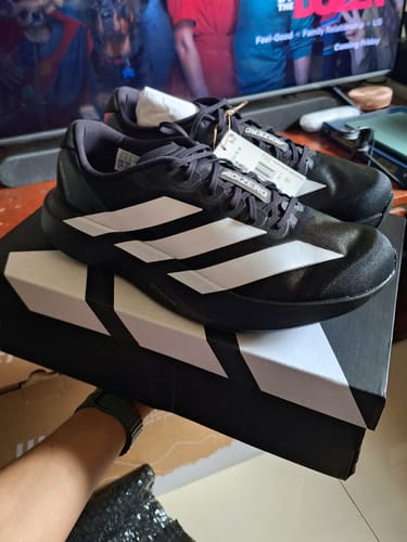 Customer's new black adidas Adizero EVO SL running shoes resting on top of the shoebox.