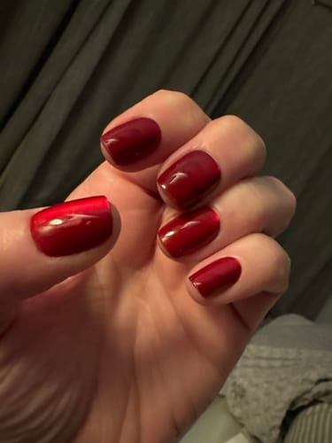 Customer's hand with shimmery red Cranberry Crush press-on nails after 4 days of wear.