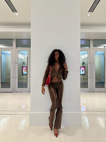 Reviewer standing in a hallway wearing the brown denim Villain Moto Jacket as part of a matching set.