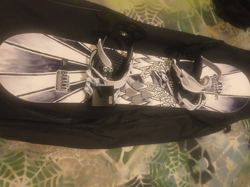 Reviewer's Union Cadet Mini Snowboard Bindings mounted on a snowboard inside an open carrying bag.