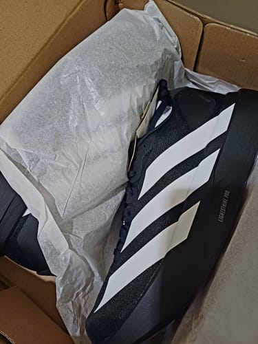 Customer's black and white Adizero EVO SL running shoes inside the shoebox.