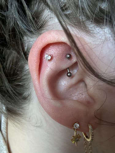 Reviewer wearing the Heartthrob flatback gold earring, a crystal heart stud, in their ear cartilage.