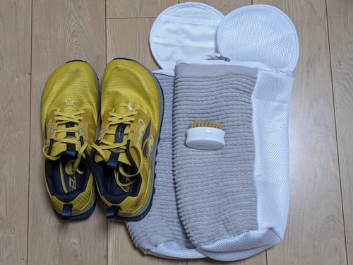 レビュー投稿者の黄色い靴と洗濯ネットの横に置かれたプレミアム洗浄ブラシ。