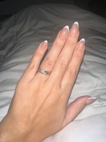 Reviewer's hand showing the almond-shaped Mermaids Tail press-on nails with a classic French manicure finish.