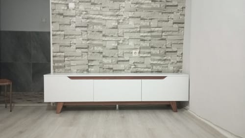 Müşterinin taş duvarın önüne kurduğu beyaz ve ceviz renkli modern Rani TV ünitesi.