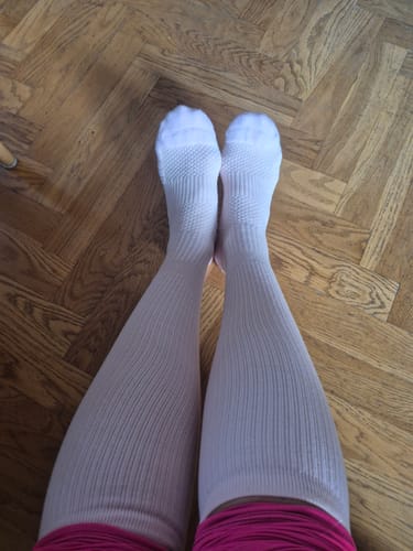 En kund som visar sina ben i de vita Diasocks Stödstrumporna.
