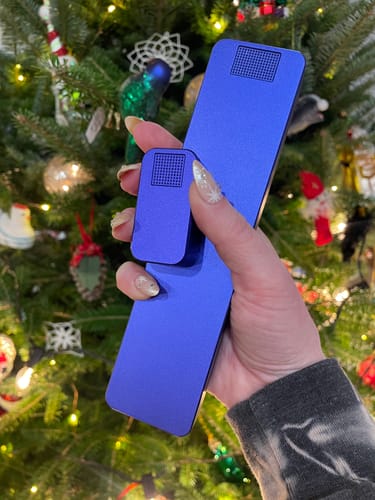 Reviewer holding the sleek, purple 2-Pack Bundle of cases in front of a Christmas tree.