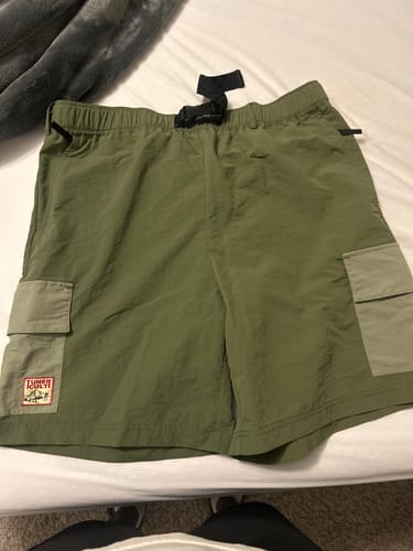 Reviewer's green TREKKER AMPHIB SHORTS with lighter green cargo pockets laid flat on a white surface.