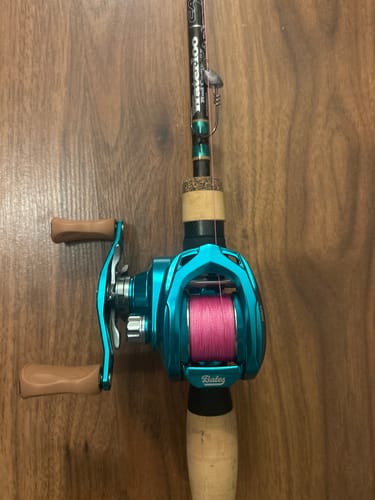 Reviewer's Glades Green Bates Salty Hundo reel spooled with pink line and mounted on a matching fishing rod.