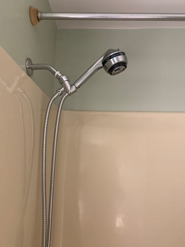 Customer's silver 2 Inch Shower Head with a long hose installed in a tub shower.