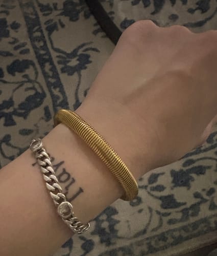 Rezensentin trägt das goldene, gerippte Sabrina Armband an ihrem Handgelenk.