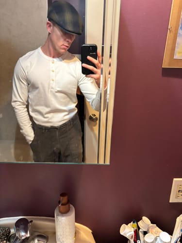 Reviewer in a fitted, white Vintage Long Sleeve Henley Shirt taking a mirror selfie.