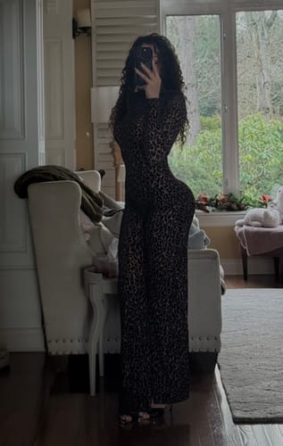 Reviewer taking a mirror selfie in the long-sleeve, leopard print Burnout Wide-Leg Jumpsuit in a well-lit room.