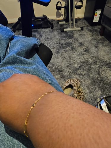 Reviewer wearing the delicate gold Multi Signature Bracelet on their wrist.