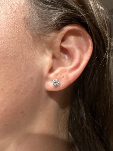 Customer wearing the M & Co. 3-Prong Martini Setting Diamond Stud Earring to show its size on the ear.