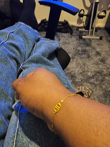 Customer showing the monogram detail on their dainty Multi Signature Bracelet.