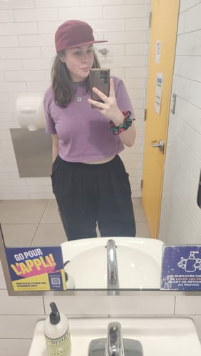 Reviewer taking a mirror selfie while wearing the purple Occupied Mind Mineral Wash T-Shirt.
