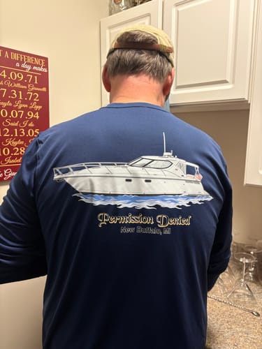 Customer seen from the back wearing a navy Dri-Fit Custom Boat Shirt with a custom boat illustration.