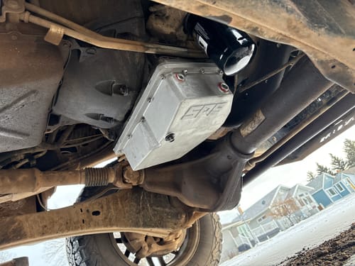 Customer's silver SPE Motorsport Oil Pan installed on the dirty undercarriage of their truck.