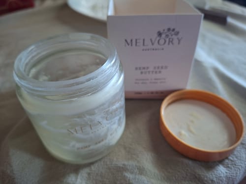 Reviewer's open jar of Hemp Seed Butter with the lid and box visible.