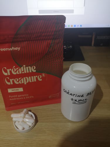 Client montrant son sachet de Créatine Creapure® à côté d'un pot et de gélules qu'il a préparées.