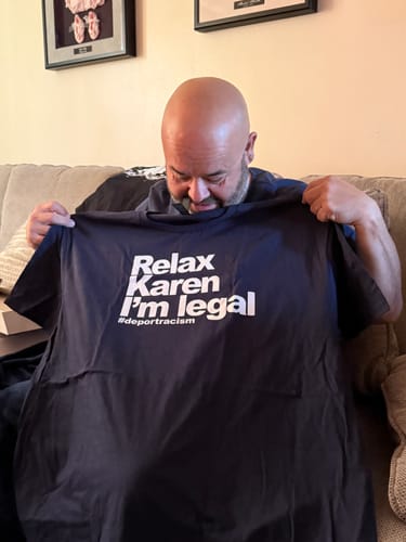 Customer holding up their new dark Relax Karen I'm Legal OG T-Shirt to display the text.