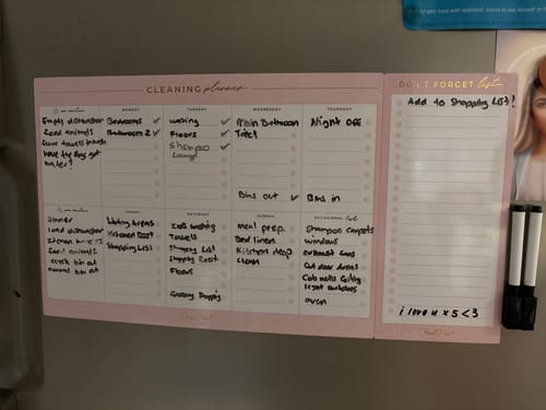 Reviewer's blush pink Magnetic Cleaning Planner on a fridge, filled out with handwritten cleaning tasks.