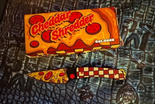 Customer's Kizer Cheddar Shredder knife with a pizza-design blade and checkered handle, displayed next to its themed box.