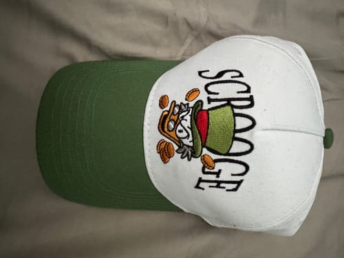 Reviewer's white and green curved brim hat with an embroidered Scrooge McDuck design on the front.