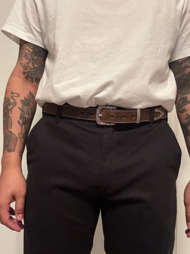 Customer wearing the brown Dakota Bison belt with a decorative silver buckle and black pants.