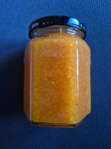 Ein Kunde zeigt die selbstgemachte Marmelade aus den Bio-Mandarinen Nova in einem Glas.