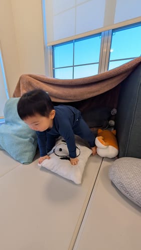 Customer's child playing indoors wearing the deep blue Merino Wool Base Layer leggings and top set.