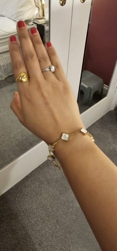 Reviewer wearing the Celine Clover Bracelet with white mother of pearl motifs on their wrist.