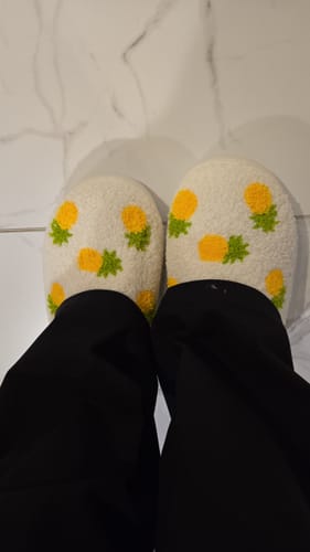 Reviewer wearing the fluffy pineapple-print Fruits Slides Slippers on a white tile floor.
