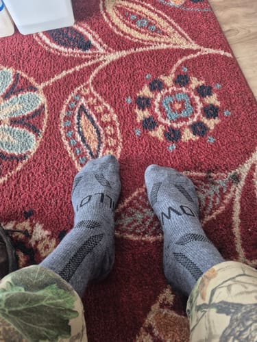 Customer's point-of-view showing their feet in a pair of grey Men's Alpaca Socks.
